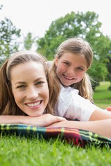 Happy mother with daughter lying at park