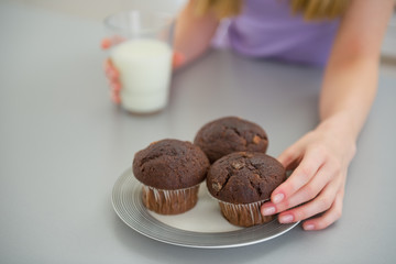 Closeup on young woman taking chocolate muffin
