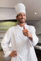 Cheerful young chef looking at camera showing thumb up