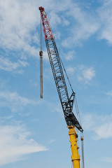 Kranausleger vor blauem Himmel mit Wolken