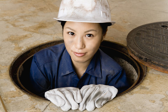 female worker looking out manhole