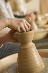 hands of woman turning pottery wheel
