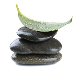 Spa stones with green leaf, isolated on white