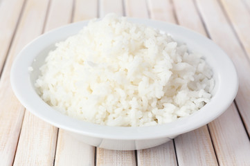 Cooked rice in bowl on wooden background