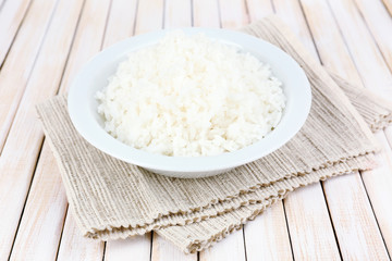Cooked rice in bowl on wooden background