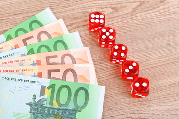 Red dices and money, on wooden background
