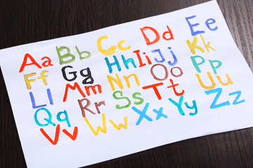 Alphabet watercolors on wooden background