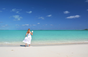 Fototapeta na wymiar Girl in the hat on the beach of Exuma, Bahamas