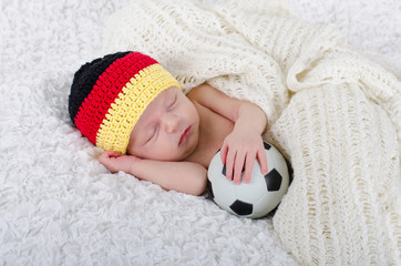 Newborn mit Deutschlandmütze und Fußball