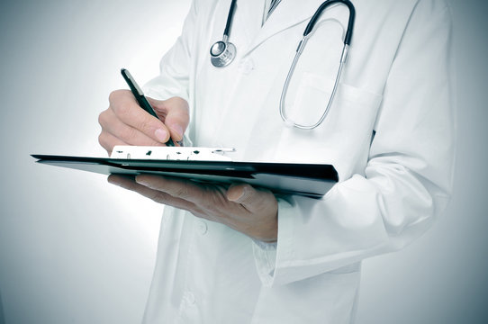 doctor writing in a clipboard