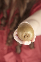 Junge Frau mit einer Kiwi