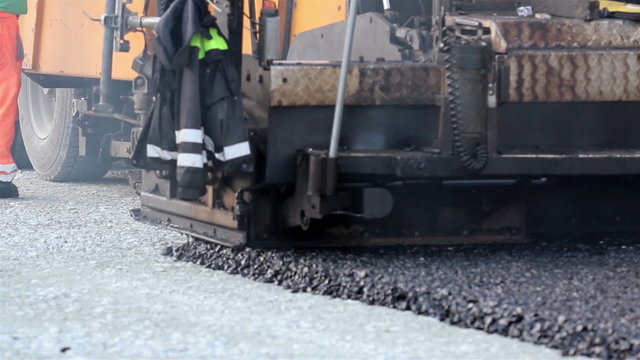 Asphalt paver applying asphalt on the highway
