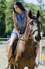 Foto op Canvas Young woman riding on the horse © BGStock72