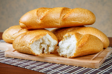 Pile of white rolls on a kitchen table