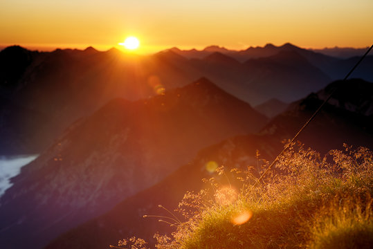 back light of sunset in mountains with warm lighted grass