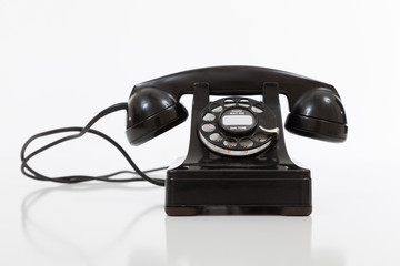 Black, vintage rotary phone on  white