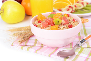 Delicious oatmeal with fruit in bowl on table close-up