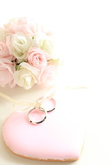 pink icing cookie with wedding rings