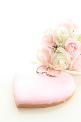 pink icing cookie with wedding rings