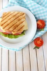 Tasty sandwich with ham on wooden table