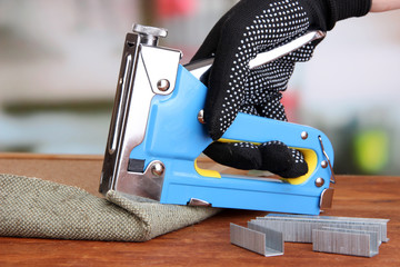 Fastening fabric and board using construction stapler - Powered by Adobe