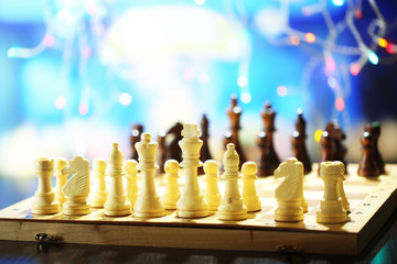 Chess pieces on board on bright background