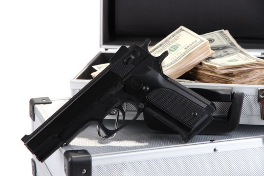Cases with money and guns, isolated on white