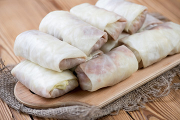 Uncooked cabbage leaves stuffed with meat filling, close-up