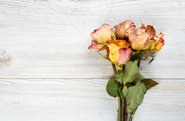 dried roses on wooden surface