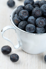 blueberries in a metallic cup on wooden table