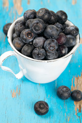fresh blueberries in a cup on wooden table