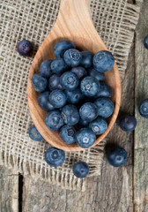 fresh blueberries in a wooden spoon over wooden table