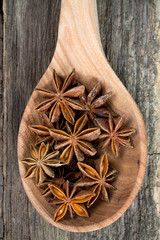 star anise in a spoon on wooden surface