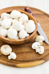 Fresh mushrooms in a cup on a wooden surface