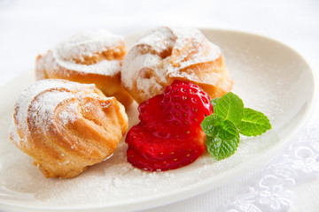 profiteroles with cream and strawberries.