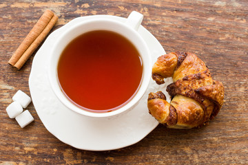 Cup of tea with croissant and cinnamon