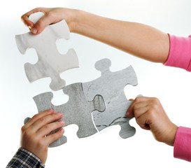 Kids connecting the jigsaw puzzle