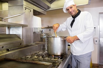 Smiling male chef preparing food in kitchen