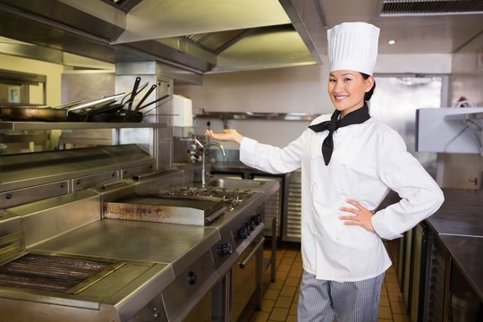 Confident female cook in kitchen
