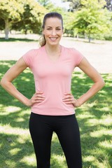 Sporty woman with hands on hips at park