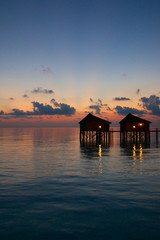 Pair of water villas at dawn Maldives