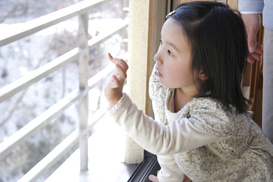 girl trying to draw picture on window