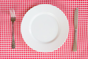 Fork Knife and Plate isolated on a red table cloth