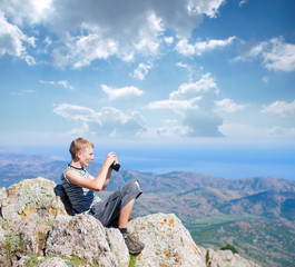 Naklejka na ściany i meble tourist on top of a mountain takes a snapshot of the nature