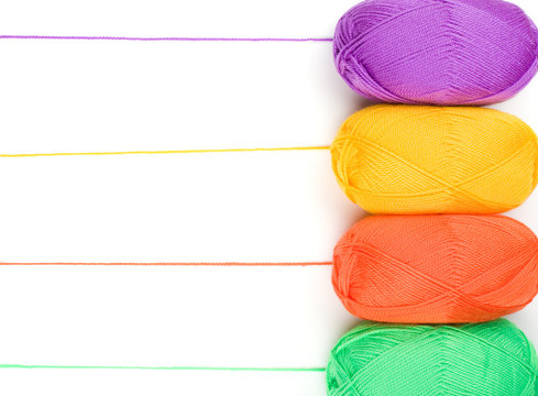 stack of yarn skeins in yellow, orange, green, purple colors on