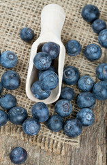 fresh blueberries in a wooden spoon over wooden table