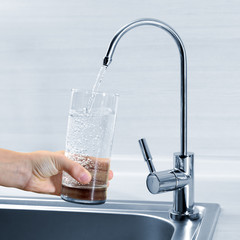 Filling glass of water in hand from kitchen faucet - 61905145