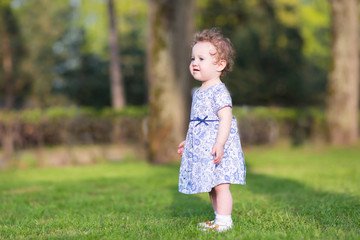 Adorable baby girl walking in the garden