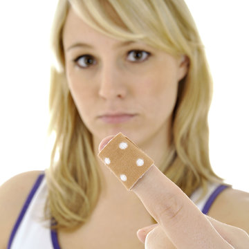 Frau mit Pflaster auf Finger-Verletzung