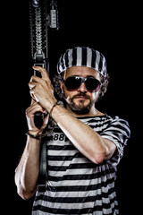 Mutiny, Prison riot concept. Man holding a machine gun, prisoner